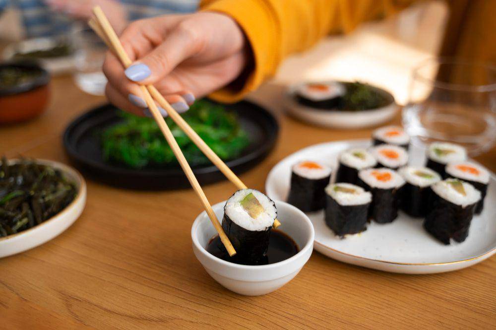 ilustrasi mencelupkan maki sushi ke dalam kecap asin (freepik.com/freepik)