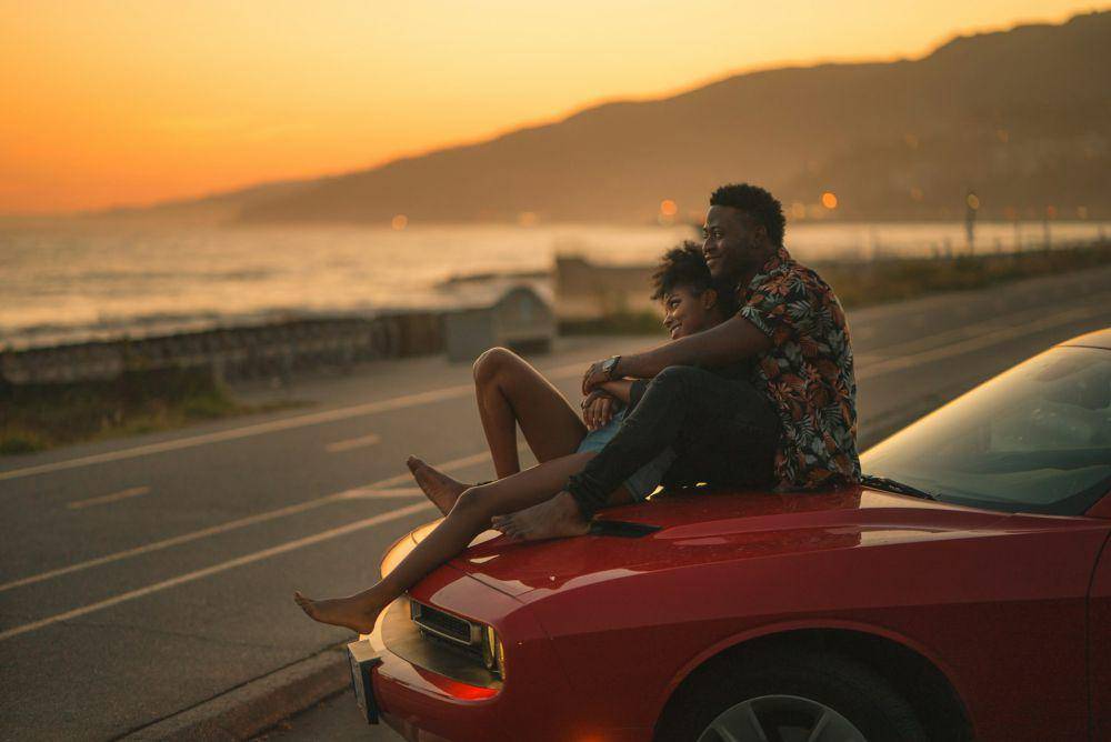 pasangan menikmati sunset di atas mobil (unsplash.com/@karsten116)