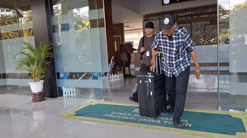 Penyidik KPK membawa koper saat keluar dari Kantor Dinas Peternakan Provinsi Jawa Timur, Rabu (16/10/2024). (IDN Times/Dok. Istimewa).