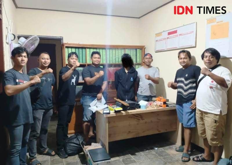 Tersangka IA posisi wajah blur hitam diapit petugas saat diamankan di Polsek Waru (IDN Times/Ervan)