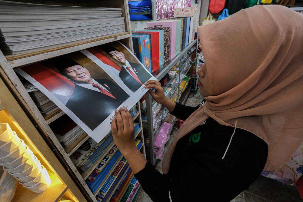 Pekerja menunjukkan foto Presiden dan Wakil Presiden terpilih Prabowo Subianto dan Gbran Rakabuming Raka sebelum dibingkai di salah retail di Kendari, Sulawesi Tenggara, Minggu (20/10/2024). (ANTARA FOTO/Andry Denisah)