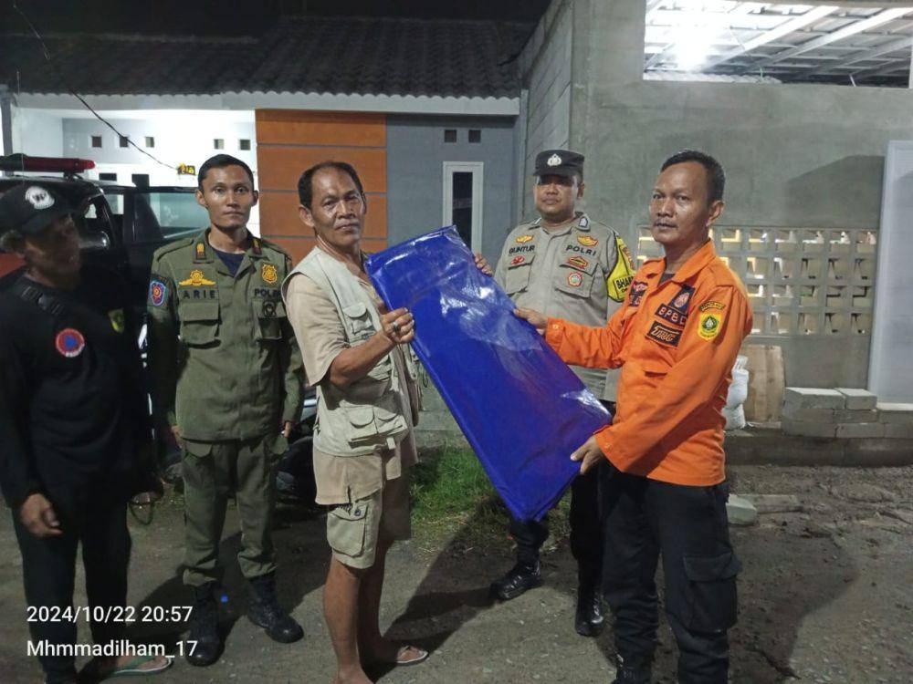 Warga Desa Gunungsari, Kecamatan Citeureup, Kabupaten Bogor, mendapat bantuan terpal dampak angin puting beliung merusak rumahnya, Selasa (22/10/2024) sore. (Humas Polres Bogor).