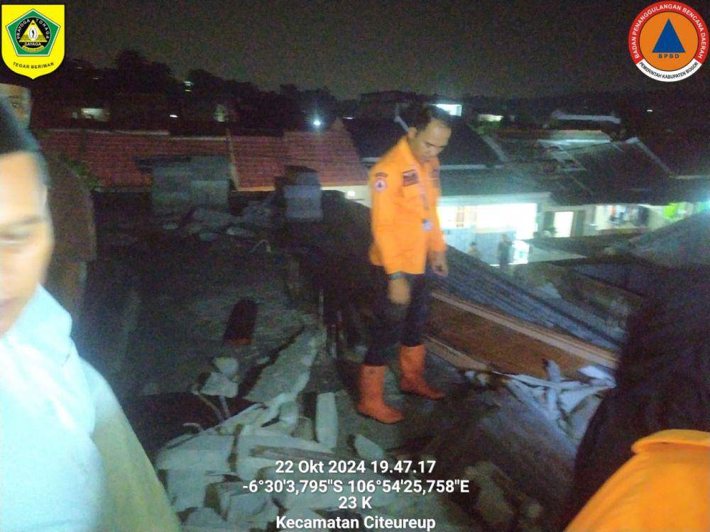 Petugas BPBD sedang mengecek kondisi atap dampak puting beliung di Desa Gunungsari, Kecamatan Citeureup, Kabupaten Bogor, Jawa Barat, Selasa (22/10/2024) malam.