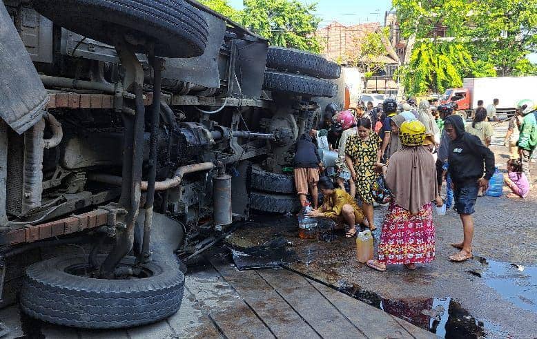 Warga berebut minyak goreng yang tumpah dari truk kontainer terbalik di depan kampus UNM Jl AP Pettarani Makassar, Kamis (24/10/2024) (IDN Times/Darsil Yahya)