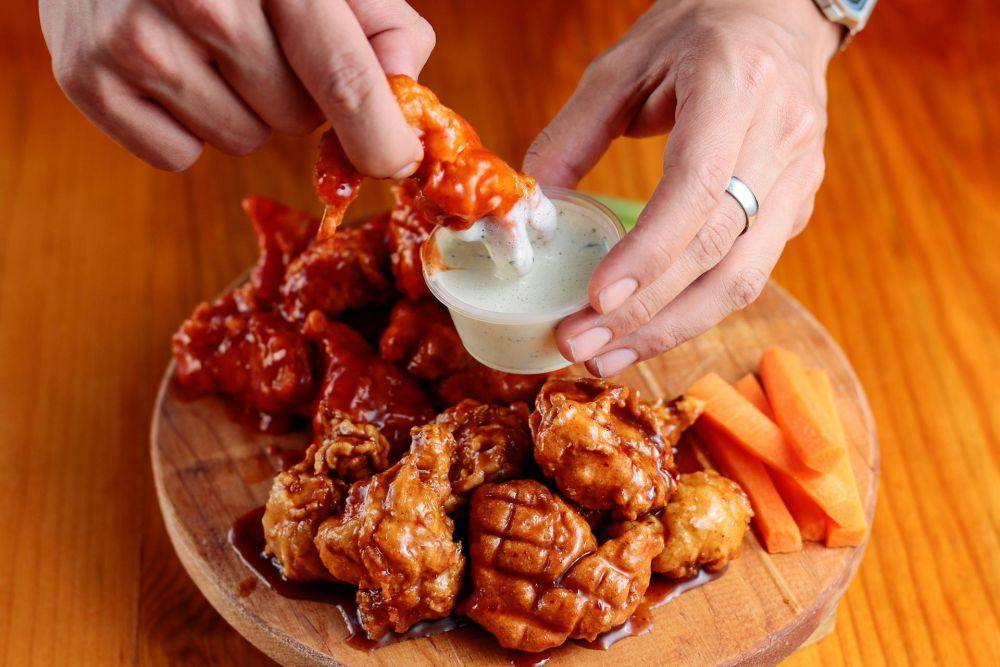 ilustrasi menikmati buffalo chicken wings (pexels.com/Sergio Arreola)