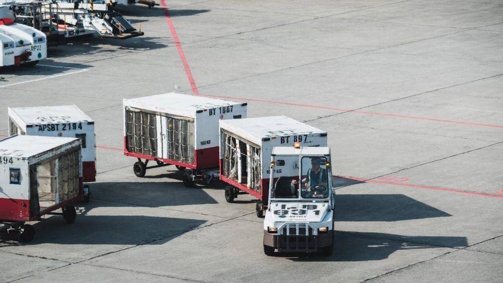 ilustrasi mobil yang membawa koper di bandara (unsplash.com/Goh Rhy Yan)