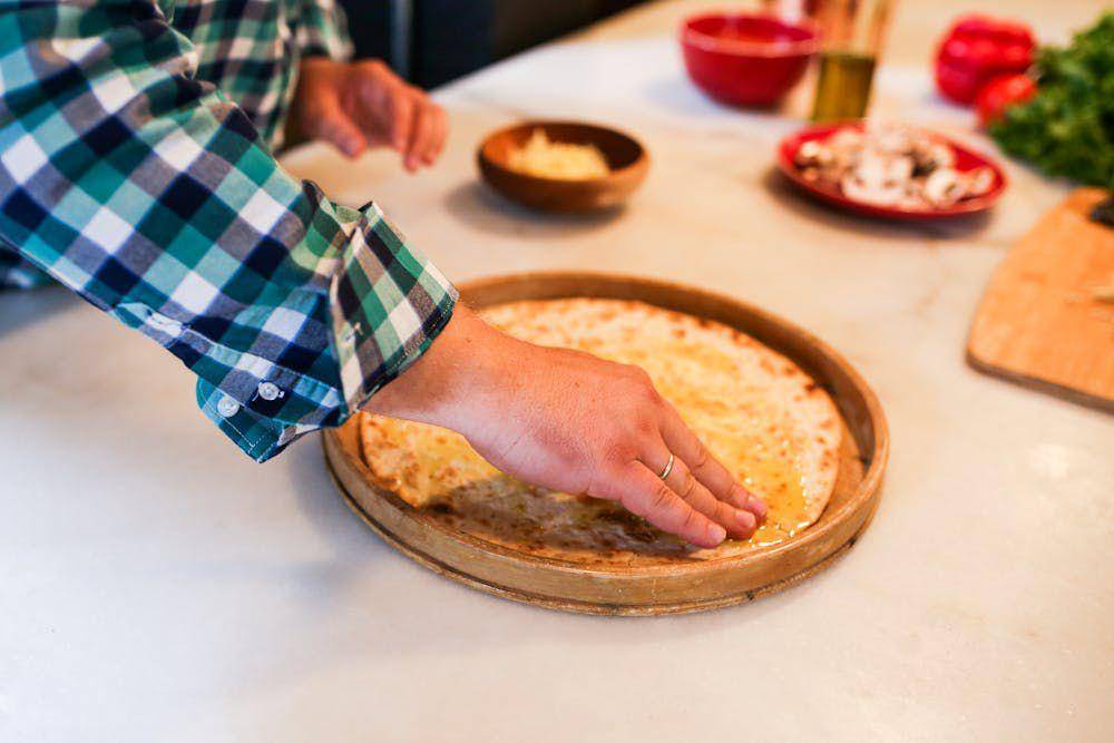 ilustrasi mengolesi adonan pizza dengan minyak zaitun (pexels.com/RDNE Stock project)
