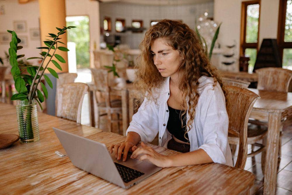 Wanita bekerja di coffeshop yang memiliki sirkulasi udara baik (pexels.com/Yan Krukau)