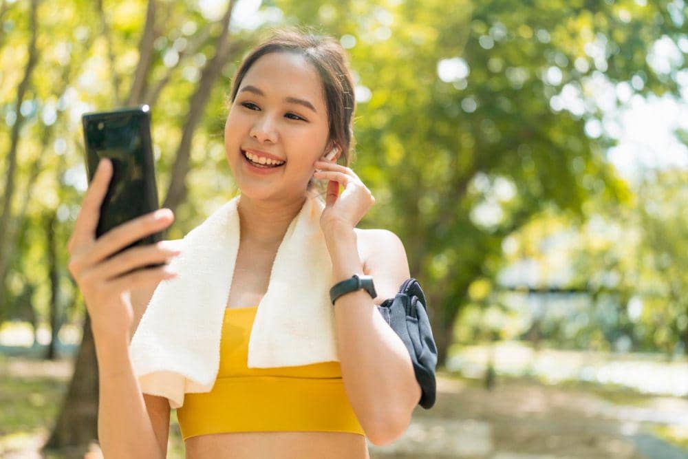 Ilustrasi wanita olahraga sambil bermain gedget (freepik.com/Lifestylememory)