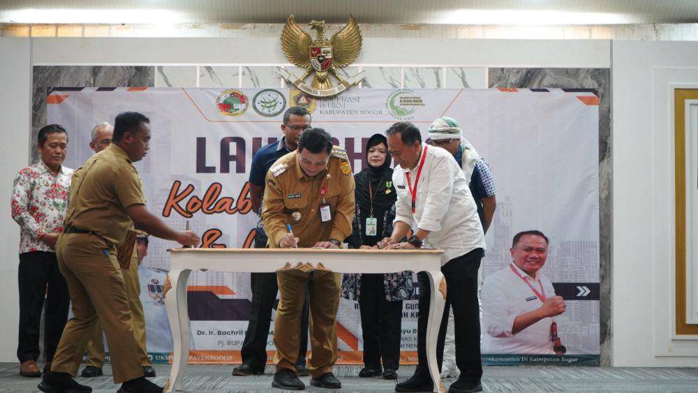 Pj. Bupati Bogor, Bachril Bakri saat menandatangani kolaborasi UMKM dengan koperasi. (Humas Pemkab Bogor).