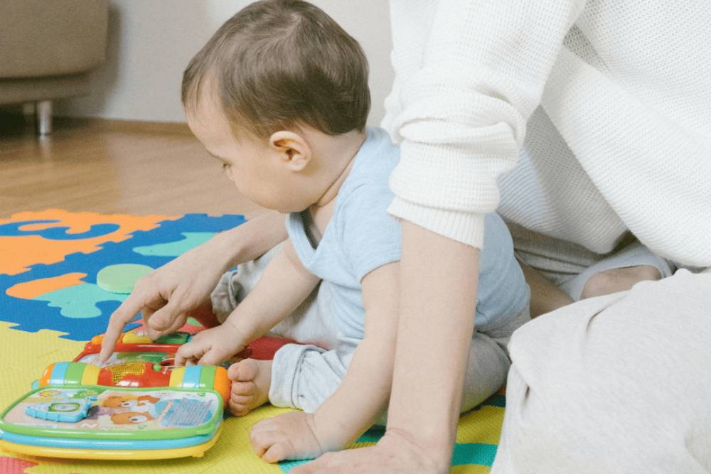 illustrasi bayi sedang bermain busy book (pexels.com/Meruyet Gonullu)
