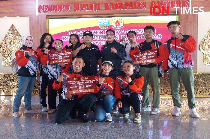 Sebagian para atlet Banyumas yang berlaga di Porprov 2023 silam berbunga bunga usai bonus yang dijanjikan pemerintah cair, nampak mereka tersenyum saat foto bersama ketua KONI Banyumas Bambang Setiawan (berdiri kelima dari kiri), Kamis (7/11/2024).(IDN Times/Cokie Sutrisno)