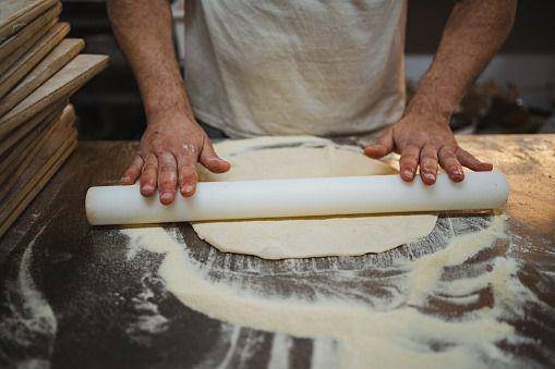 meratakan adonan pizza (istockphoto.com/Pablo Rasero)