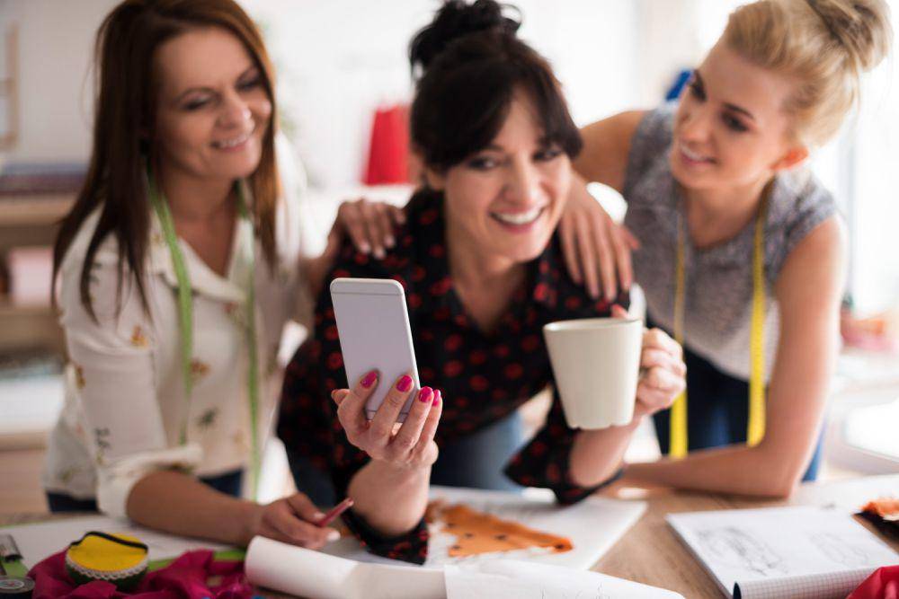 Ilustrasi wanita bermain gedget dengan teman (freepik.com/gpointstudio)