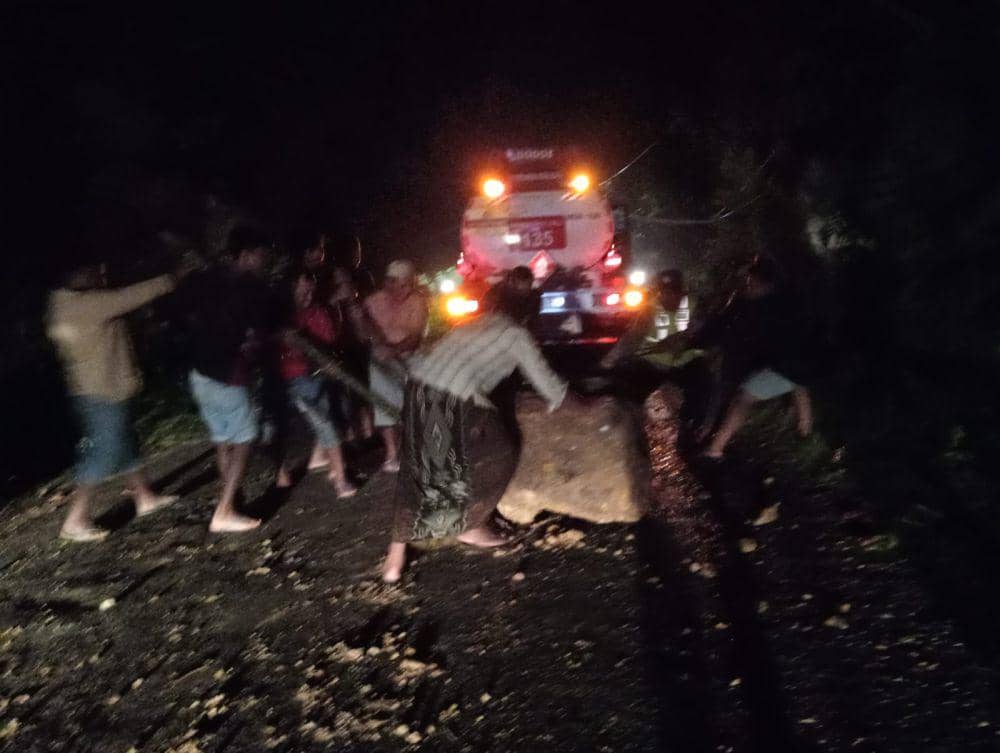 Petugas dan warga memberishkan material longsor dari jalan. IDN Times/ Dok BPBD Trenggalek