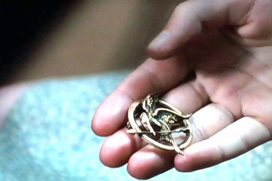 cuplikan adegan Katniss memberikan pin mockingjay ke adiknya (dok. Color Force/The Hunger Games)