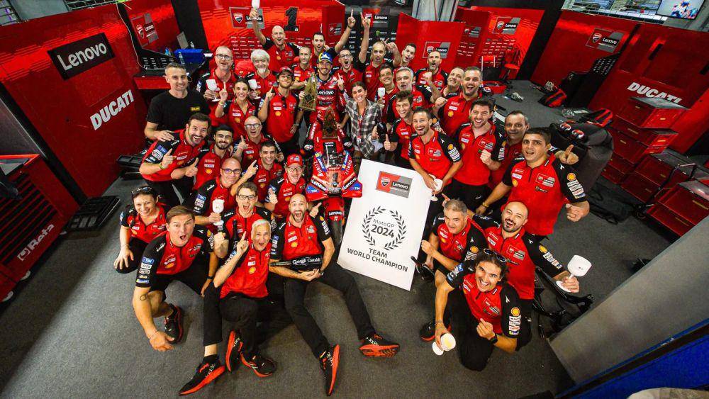 Francesco Bagnaia dan Enea Bastianini berfoto bersama kru Ducati Lenovo Team dalam perayaan gelar juara dunia tim MotoGP 2024. (motogp.com)
