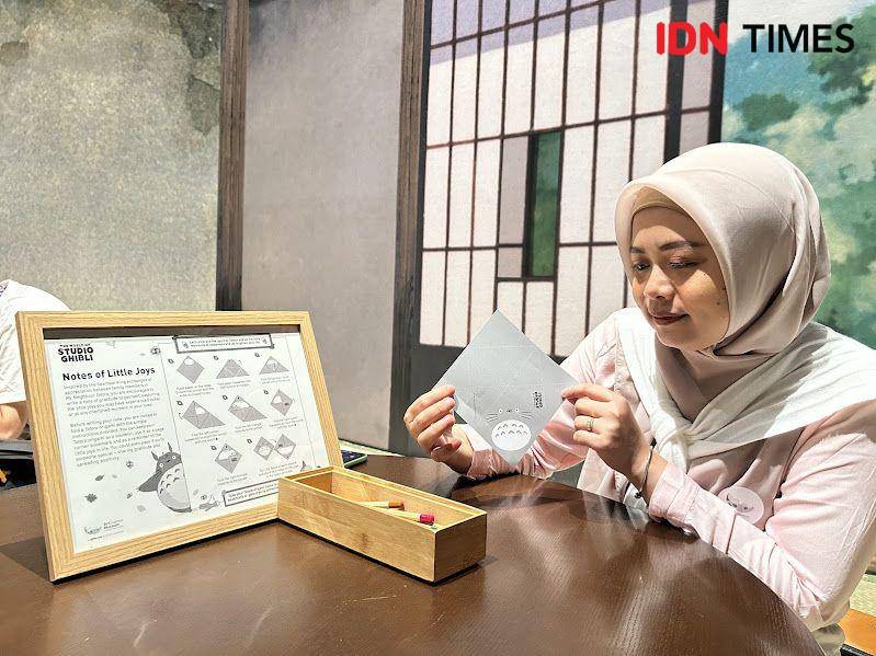 Potret seorang pengunjung sedang membuat origami Totoro di The World of Studio Ghibli, Singapura (IDN Times/Fasrinisyah Suryaningtyas)