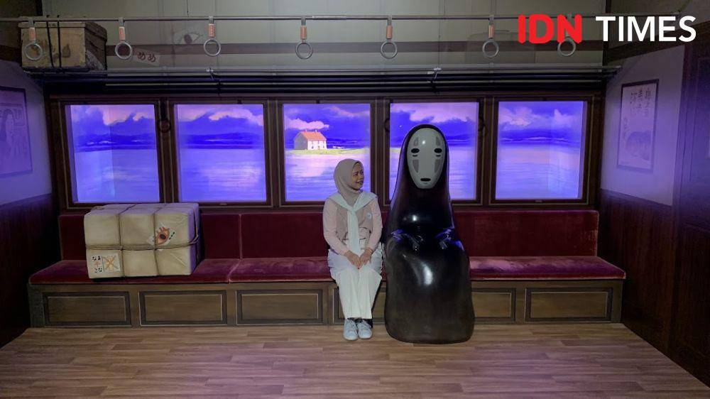Potret pengunjung berpose di samping Kaonashi di pameran The World of Studio Ghibli, Singapura (IDN Times/Fasrinisyah Suryaningtyas)
