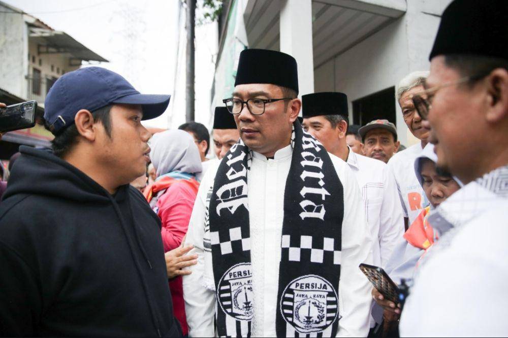 Calon gubernur Jakarta, Ridwan Kamil dikalungi syal Persija oleh The Jakmania ketika blusukan ke Pejaten Timur. (Dokumentasi tim media RIDO)