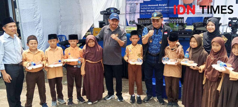 Sekda NTB Lalu Gita Ariadi memberikan makan bergizi gratis secara simbolis kepada siswa di sekitar Balai Benih Ikan Batu Lumbung Lingsar Lombok Barat, Kamis (21/11/2024). (IDN Times/Muhammad Nasir)