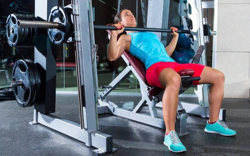 ilustrasi perempuan sedang menggunakan smith machine di gym (dok/homegymsupply.co.uk)