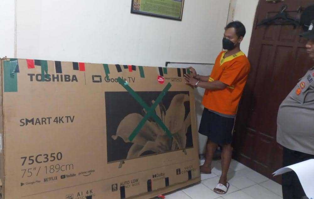 Tersangka RK dengan televisi yang dia curi. (Dok.Polresta Balikpapan)
