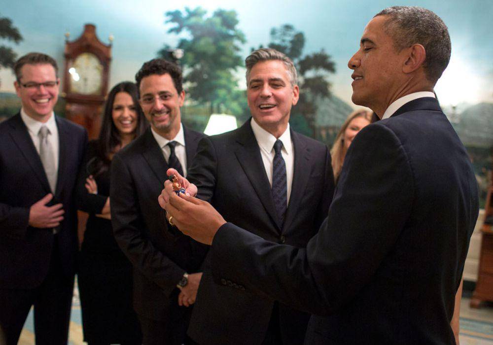 Presiden Barack Obama bercanda dengan para pemeran film "The Monuments Men" di Ruang Resepsi Diplomatik, sebelum pemutaran film di Family Theater Gedung Putih, 18 Februari 2014. Dari kiri: Matt Damon dan istrinya Luciana Damon, Grant Heslov, dan George Clooney. (commons.wikimedia.org/Foto Resmi Gedung Putih oleh Pete Souza)