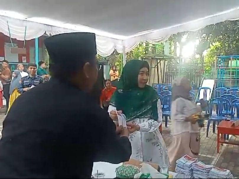 Rohmi saat menerima surat suara dari petugas KPPS (IDN Times/Istimewa)
