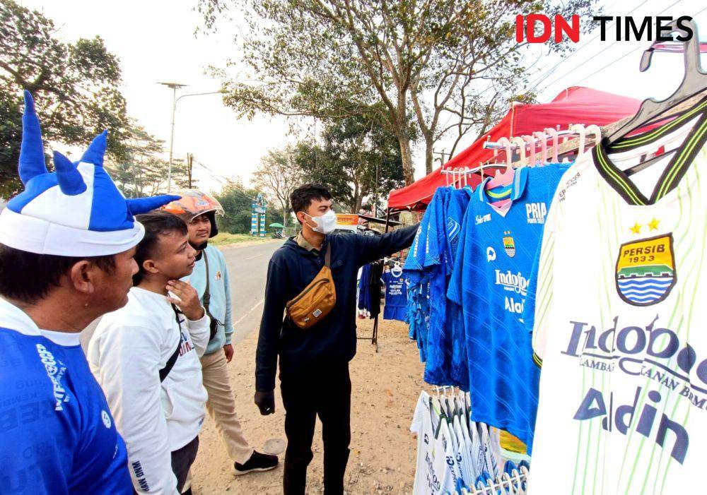 Tiga Bobotoh Persib Bandung sedang tawar-menawar untuk membeli jersey sebelum pertandingan Persib. IDN Times/Debbie Sutrisno