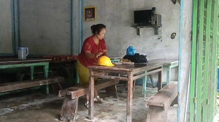 Lestari saat membersihkan warungnya yang terkena dampak longsor (dok.Istimewa)
