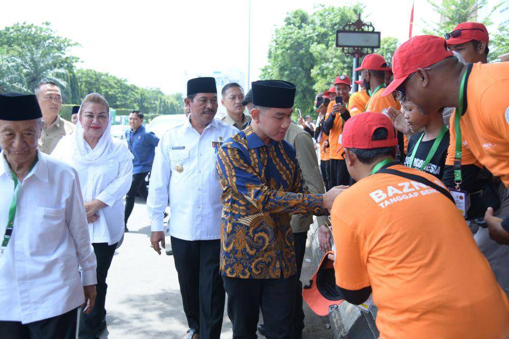 Wapres Gibran Rakabuming Raka berpeci hitam saat menyalami relawan Baznas. (IDN Times/Dok Humas Pemprov Jateng)