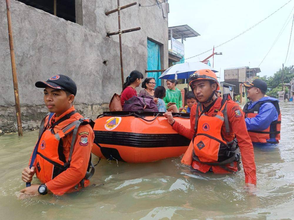 Tim BPBD mengevakuasi warga terdampak banjir di Jalan Kotipa XV, Makassar, Sabtu (21/12/2024). (Dok. BPBD Makassar)