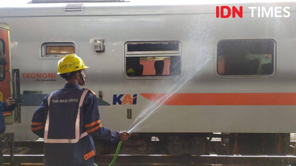 Seorang petugas menyemprotkan air untuk membersihkan kotoran yang menempel pada gerbong kereta api yang ada di Stasiun Tawang Semarang. (IDN Times/Fariz Fardianto)