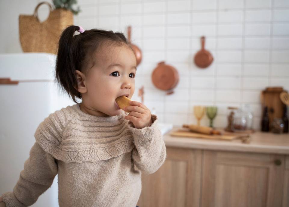 Anak balita makan camilan.