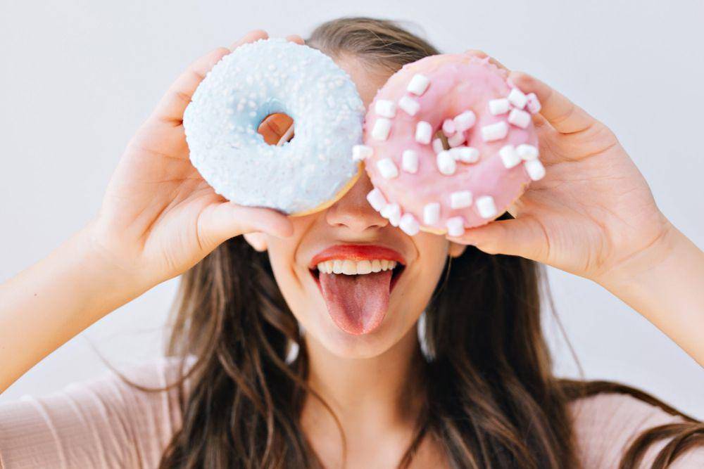 Ilustrasi wanita memegang donat (freepik.com/lookstudio)