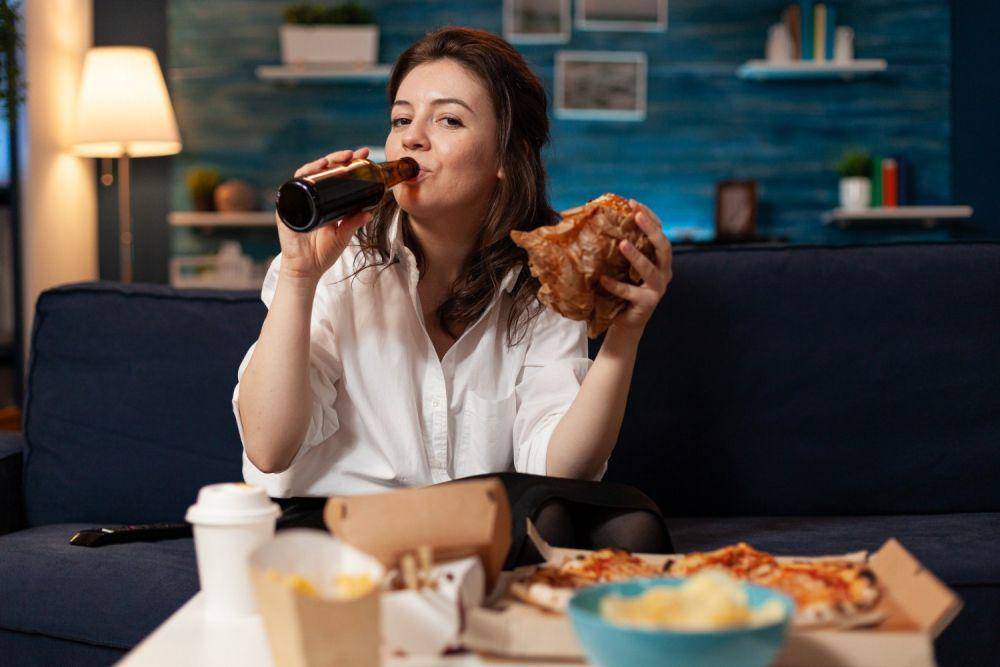 Ilustrasi wanita makan junk food (freepik.com/DC Studio)