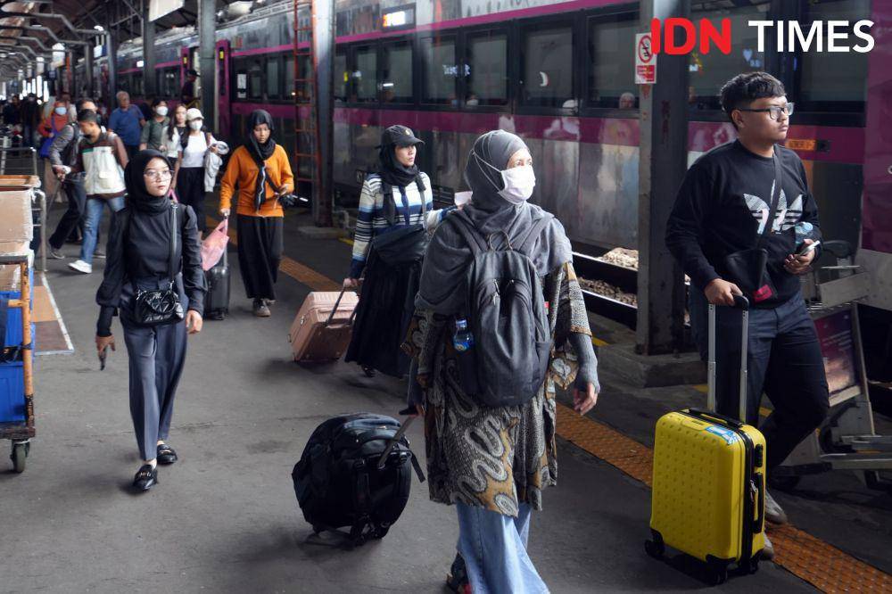 Seorang perempuan saat menarik kopernya tatkala berjalan kaki melewati gerbong kereta api yang berhenti di wilayah stasiun Daop 4 Semarang. (IDN Times/Fariz Fardianto)