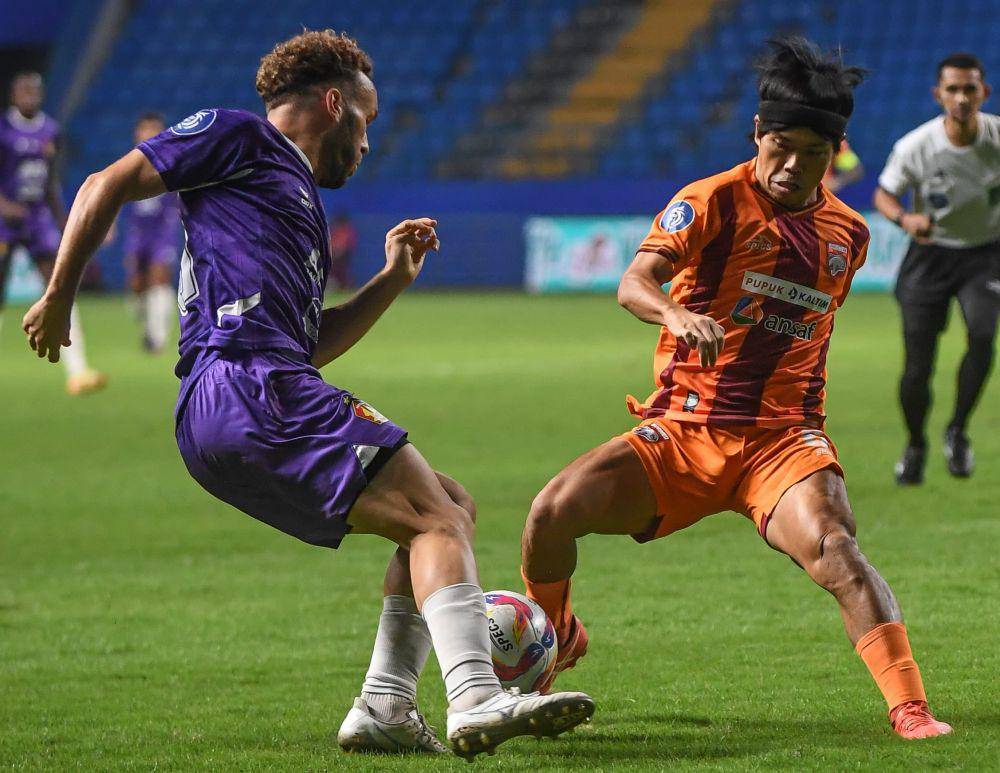Aksi pemain Borneo FC, Kei Hiroshe (jersey oranye) berdua dengan pemain Persik Ze Valente (jersey ungu) pada pertandingan di Stadion Batakan, Jumat (27/12/2024) malam. (Dok. Media Officer Borneo FC)