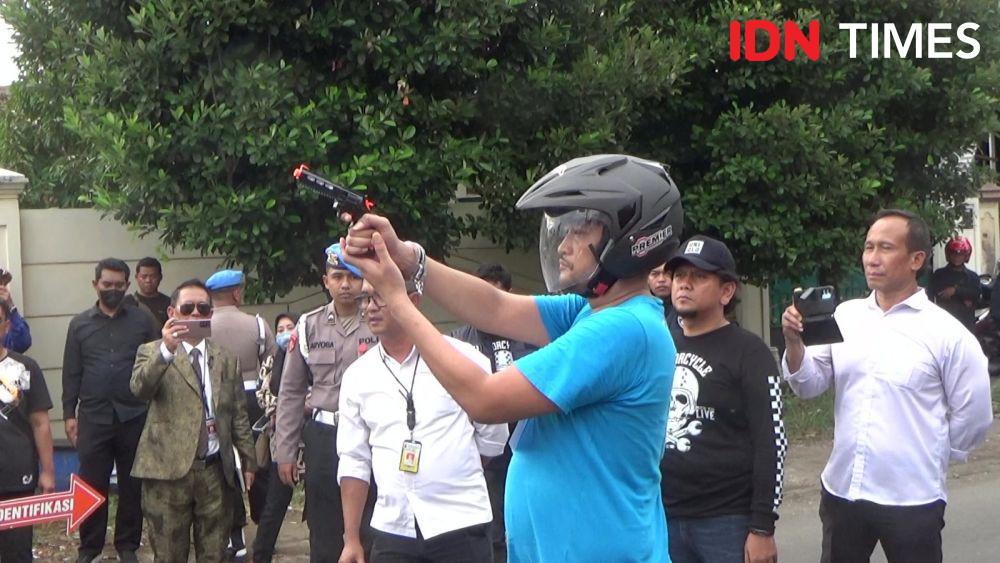 Tersangka kasus penembakan siswa Semarang, Robig Zainudin memeragakan adegan menembak korban. (IDN Times/Fariz Fardianto)