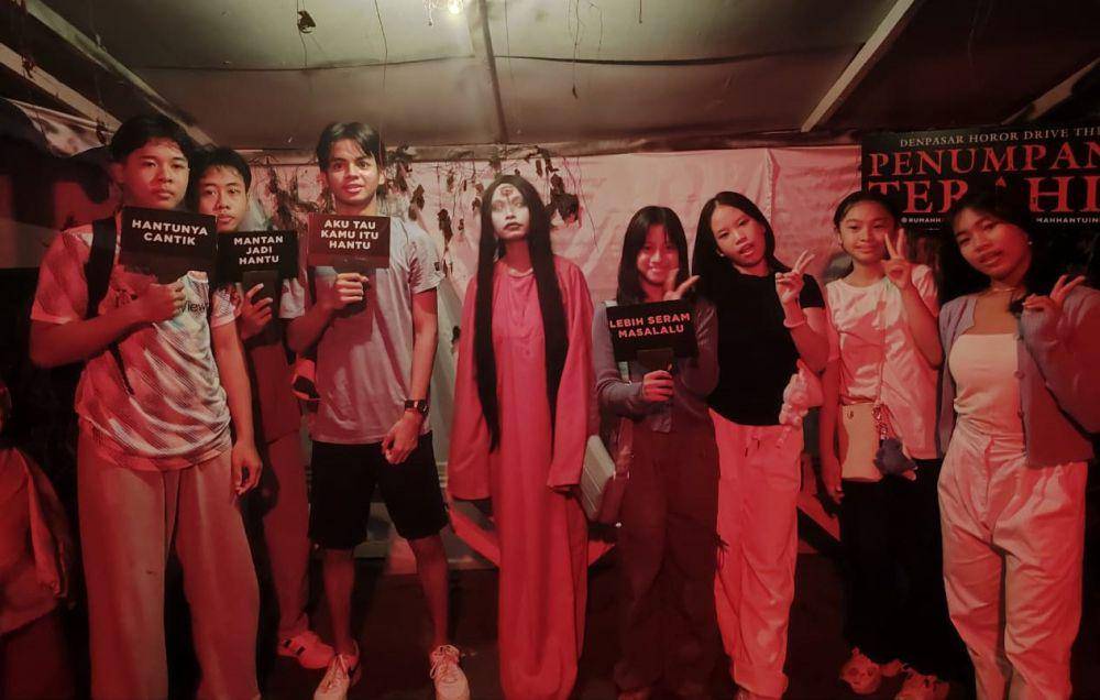 Pengunjung berfoto dengan salah satu sosok hantu di dalam rumah hantu Penumpang Terahir. (dok. pribadi/Ari Budiadnyana)