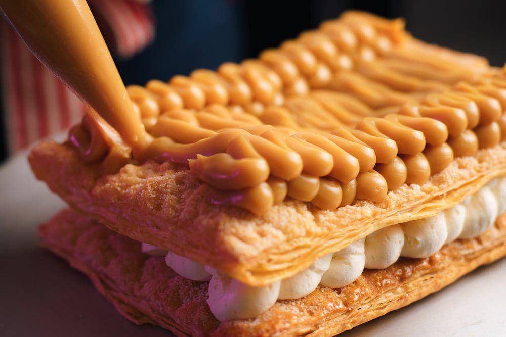 ilustrasi mengoles krim pada lapisan kue mille feuille (pexels.com/Produtora Midtrack)