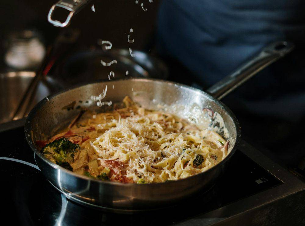 ilustrasi menambahkan keju dalam pasta yang sedang dimasak (pexels.com/cottonbro studio)