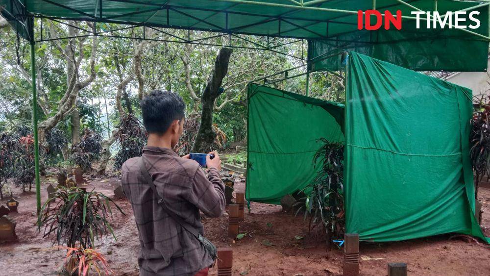 Seorang wartawan memotret persiapan ekshumasi korban pengeroyokan di pemakaman umum Tugu Dandang Mijen. (IDN Times/Fariz Fardianto)