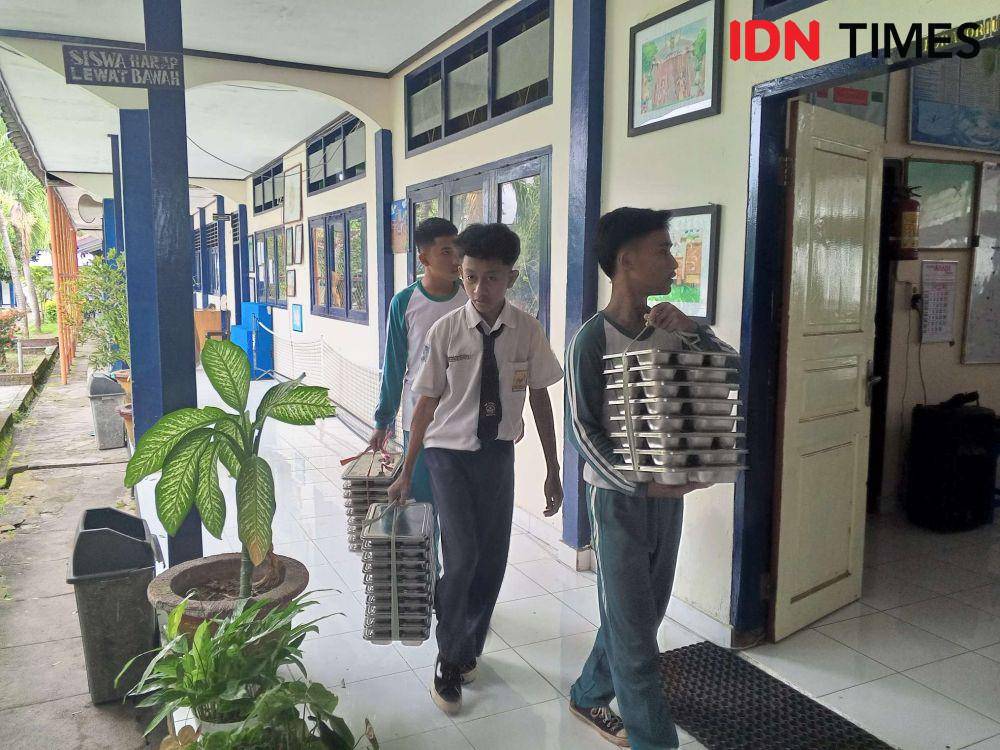 Siswa mengumpulkan kembali tempat makan. (IDN Times/Muhammad Nasir)