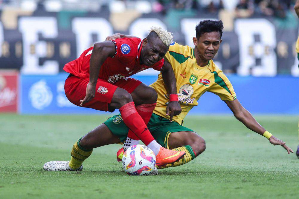Pemain Persebaya Arief Catur Pamungkas (kanan) berebut bola dengan pemain Malut United Sony Norde (kiri) dalam laga BRI Liga 1 2024/2025, Jumat (17/1/2025). ANTARA FOTO/Rizal Hanafi/tom.