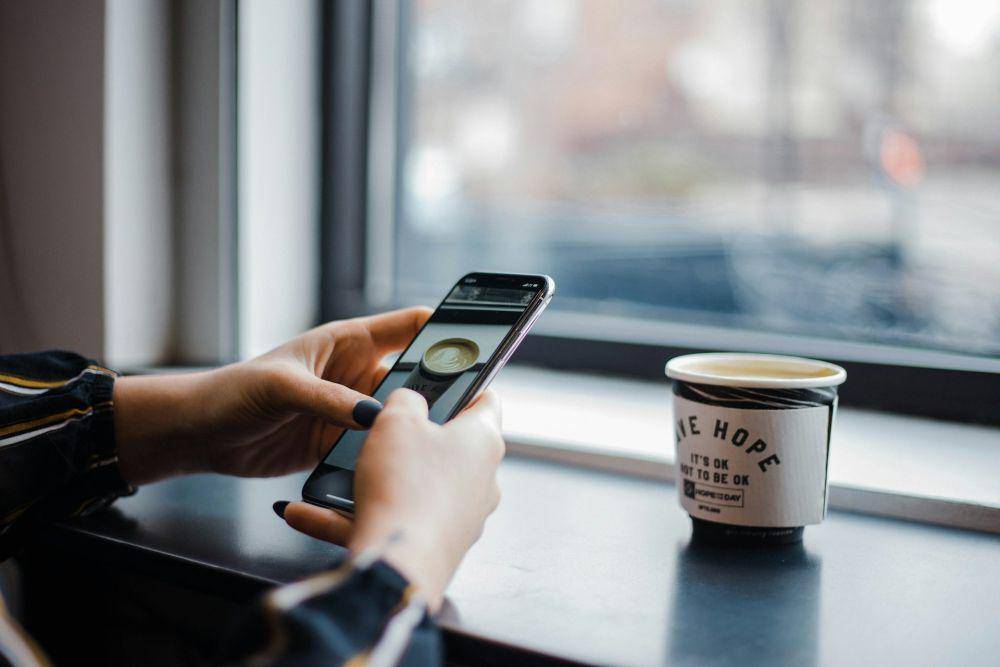 ilustrasi orang memfoto sebuah kopi dan dibagikan di media sosialnya (unsplash.com/hannah grace)