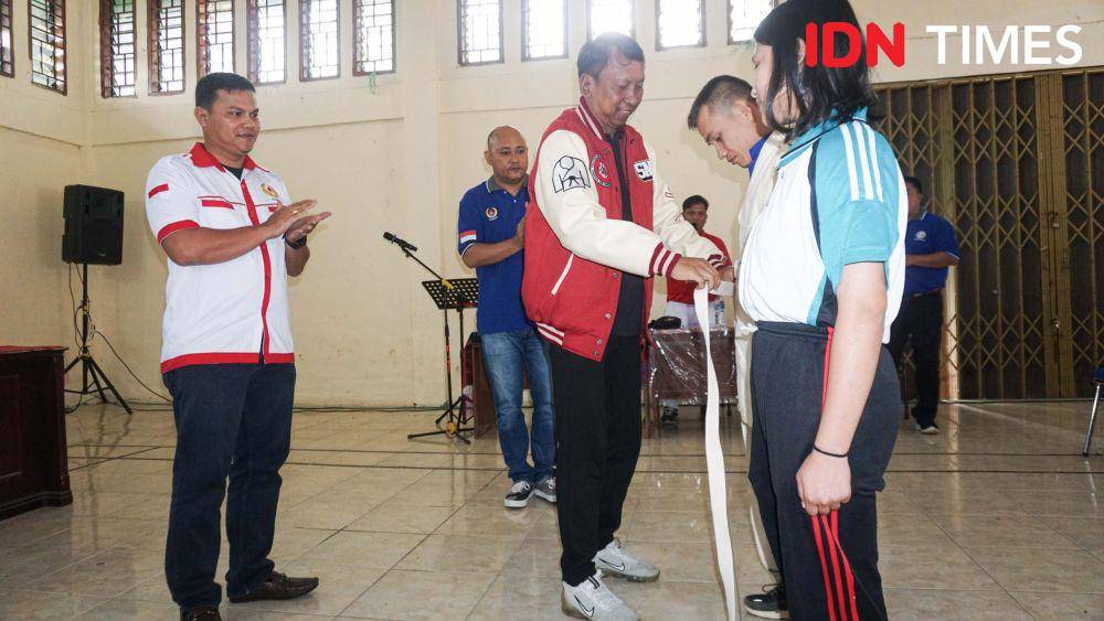 Ketum PJSI Sumut M Arief Fadhillah menyematkan judogi ke atlet Toba (IDN Times/Doni Hermawan)