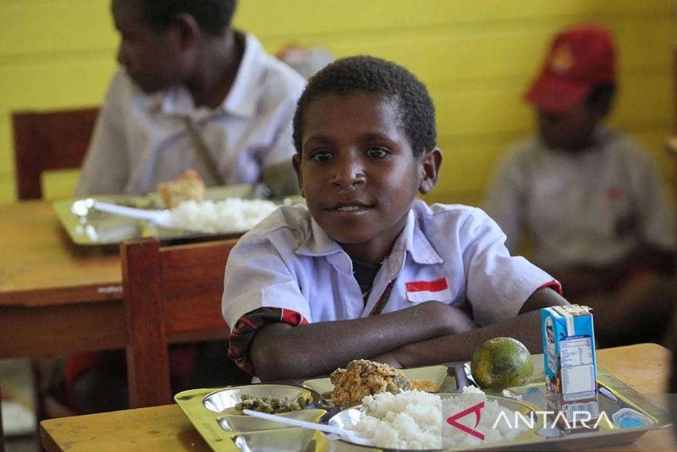 Siswa bersiap menyantap menu makan bergizi gratis perdana di SD Santo Michael Bilogae, Distrik Sugapa, Kabupaten Intan Jaya, Papua Tengah, Senin (20/1). (ANTARA FOTO/Martinus Eguay/Spt)