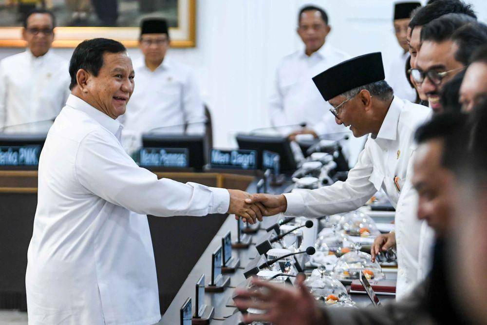 Presiden Prabowo Subianto (kiri) menyalami menteri Kabinet Merah Putih pada sidang kabinet paripurna di Kantor Presiden, Jakarta, Rabu (22/1/2025). (ANTARA FOTO/Hafidz Mubarak A)